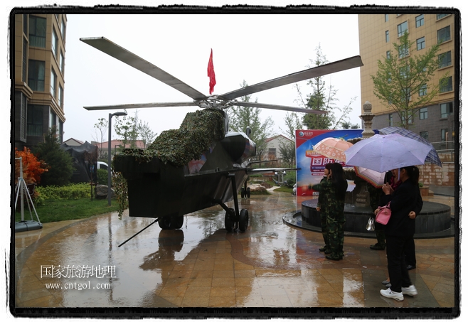 小區(qū)突然出現(xiàn)“飛機(jī)坦克”，其中殲15艦載戰(zhàn)斗機(jī)一架、99式主戰(zhàn)坦克一輛、武直-10武裝直升機(jī)一架，吸引了眾多市民雨中圍觀、合影。